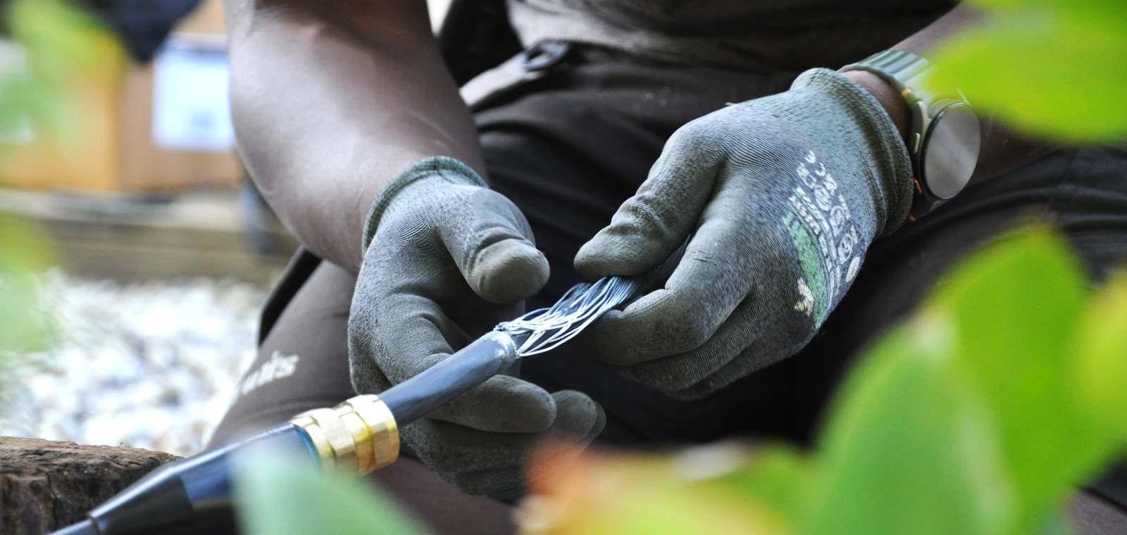 NSS Electrics electrician preparing armoured cable on a garden installation